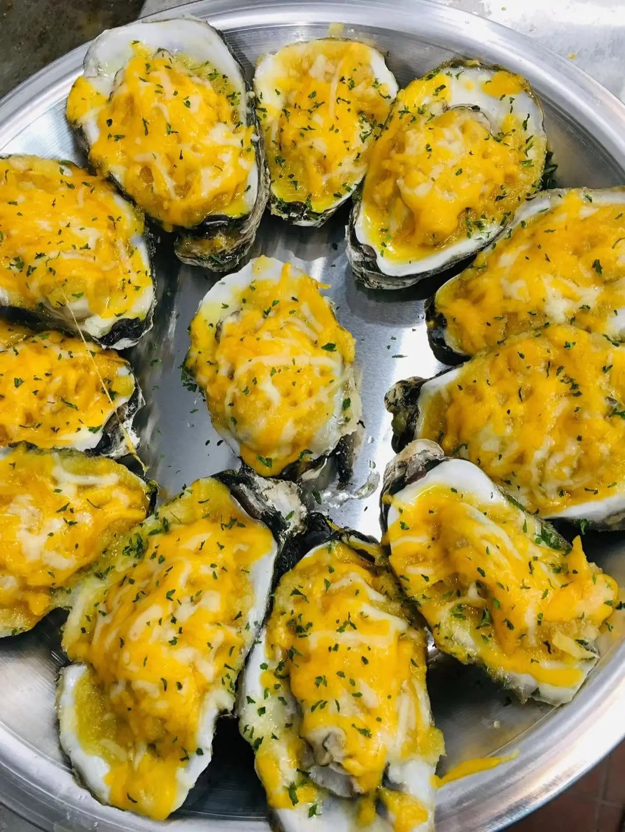 Cheese baked oysters garnished with herbs at Captain Crab, a Seafood Restaurant in Lufkin