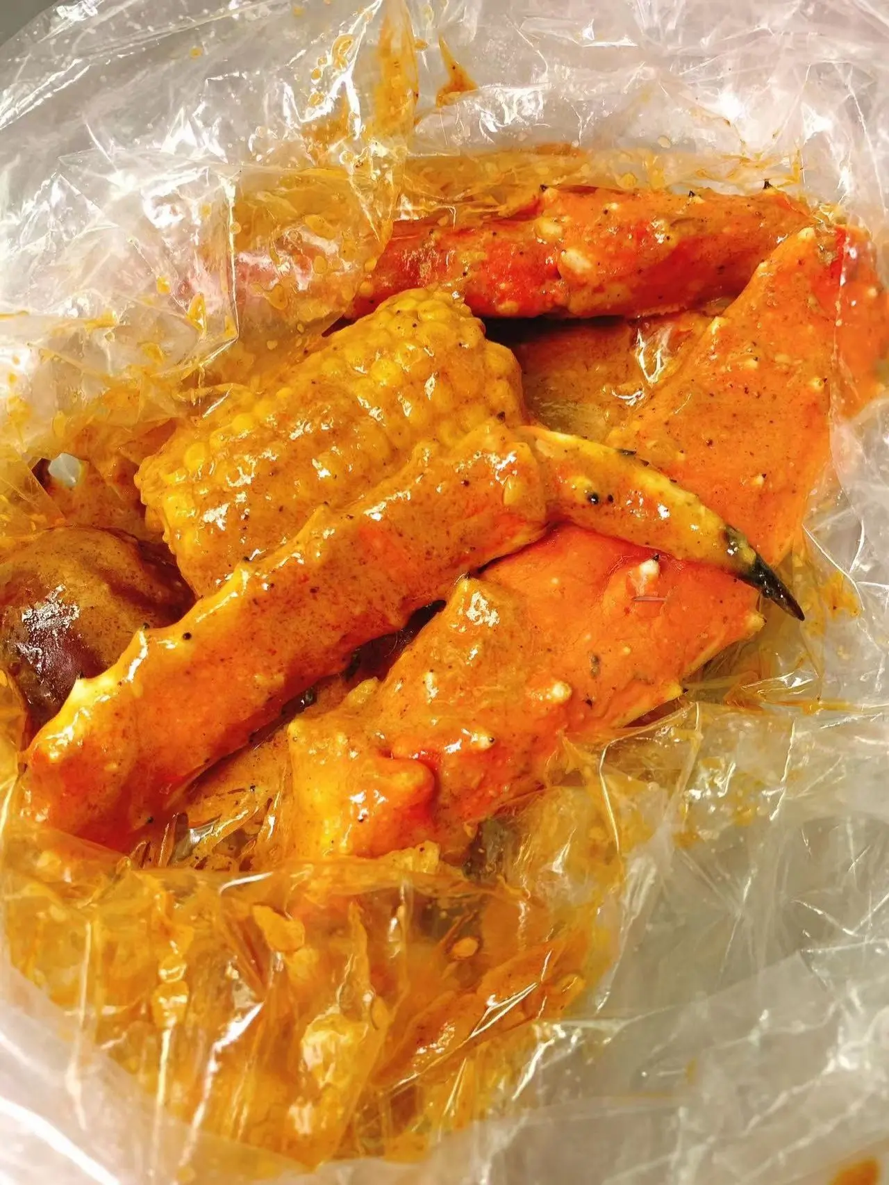 Spicy seasoned crab legs in plastic bag at Captain Crab, a Seafood Restaurant in Lufkin
